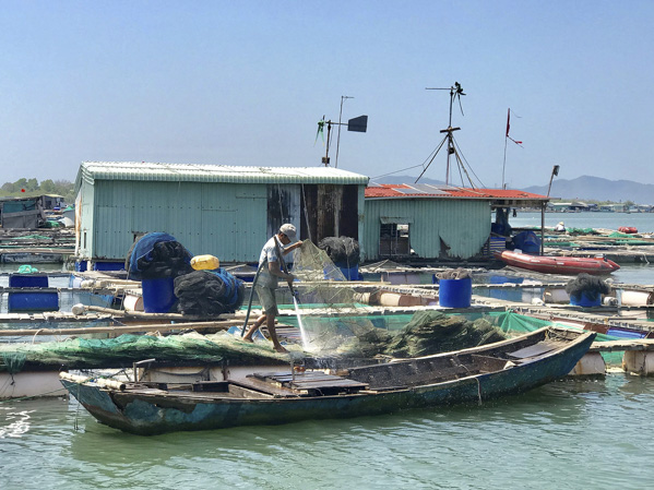 Một người dân súc rửa lưới ngay trên bè nuôi cá ở sông Chà Và. Hoạt động này góp phần làm gia tăng ô nhiễm nguồn nước trên sông. 