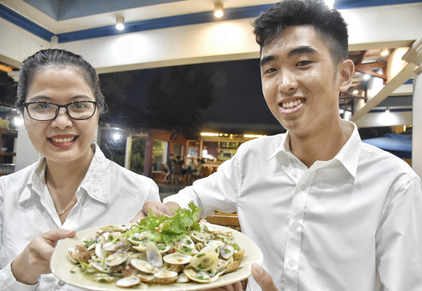 Du khách thưởng thức chang chang xào mỡ hành tại Nhà hàng biển Hồ Tràm (ấp Hồ Tràm, xã Phước Thuận). 