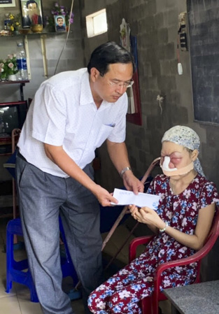 Ông Nguyễn Tấn Bản, Phó Chủ tịch UBND huyện Châu Đức trao tiền hỗ trợ từ nhà hảo tâm cho chị Đỗ Thị Trâm Anh. 
