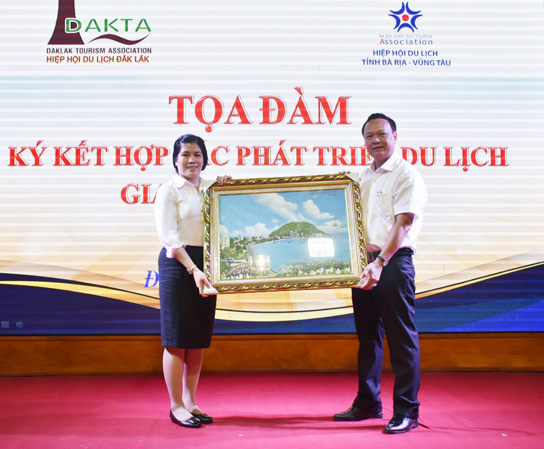 Ông Huỳnh Bách Tiến, Phó Giám đốc Sở Du lịch BR-VT tặng quà lưu niệm cho bà Nguyễn Thụy Phương Hiếu, Phó Giám đốc Sở VH-TT-DL Đắk Lắk.  