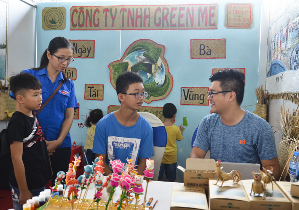 Khách tham quan và tham gia trò chơi đố vui có thưởng tại gian hàng của Công ty TNHH Green Me tại ngày hội. 
