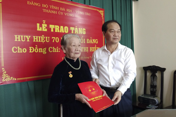 Ông Mai Ngọc Thuận trao Huy hiệu 70 năm tuổi Đảng cho bà Vương Thị Hiền.