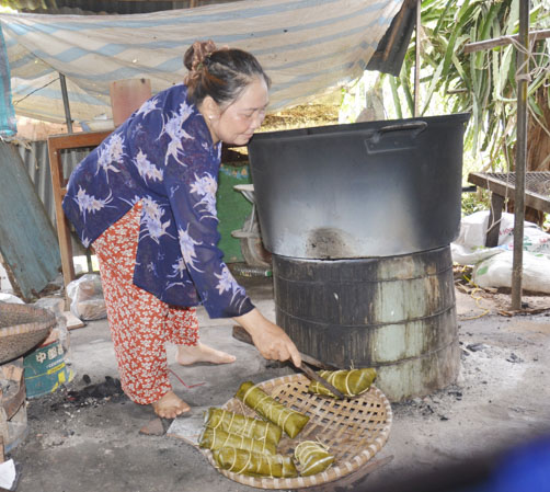 Bà Nguyễn Thị Tình vớt các đòn bánh tét bắp sau khi nấu ra khỏi nồi.