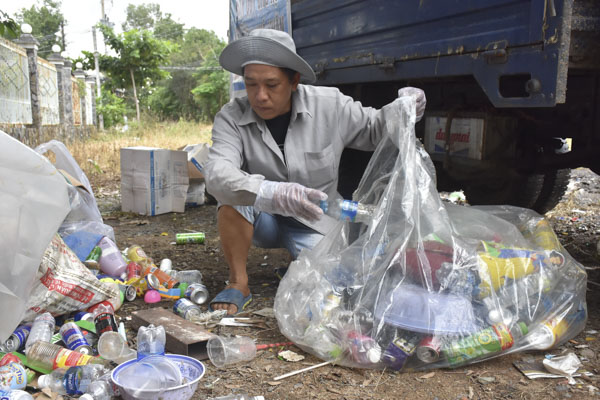 Ông Võ Minh Cường phân loại ve chai tại các điểm tập kết rác thải của người dân.