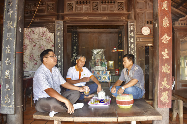 Ông Phan Văn Phên (giữa) tiếp khách trên bộ phản giữa ngôi nhà 113 năm tuổi.