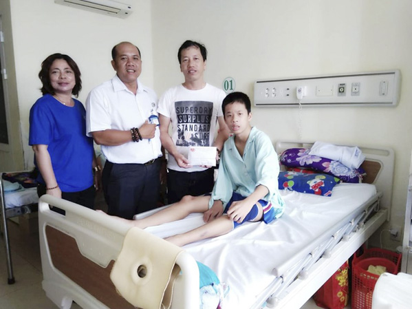 Bệnh nhân Đào Minh Tâm đã hồi phục vận động sau khi được điều trị. Trong ảnh: Các nhà hảo tâm và đại diện  BV Bà Rịa thăm hỏi, hỗ trợ chi phí điều trị cho em Đào Minh Tâm.