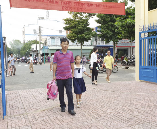 Phụ huynh Trường TH Cao Văn Ngọc (huyện Côn Đảo) đưa trẻ đến trường. Ảnh: THÁI THỦY
