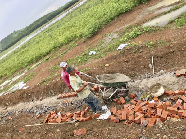 Công nhân xây dựng hàng rào bao quanh khu đất gần mé hồ Đá Bàng.