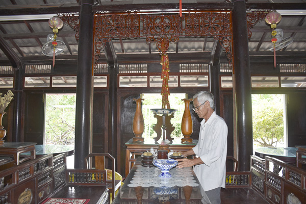 Ông Đỗ Đức Lang (24, ấp An Lạc, xã An Nhứt, huyện Long Điền) nâng niu những kỷ vật trong ngôi nhà cổ.