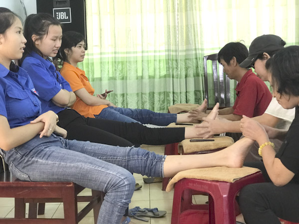 Hội viên Hội Người mù (bên phải) thực hiện phần thực hành sau thời gian được học kỹ thuật xoa bóp bàn chân.