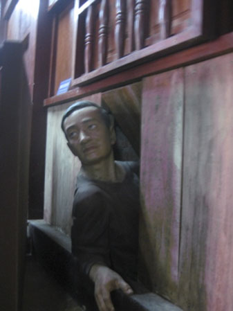 Tượng tái hiện một đồng chí cách mạng chuẩn bị vào hầm bí mật tại nhà má Tám Nhung.