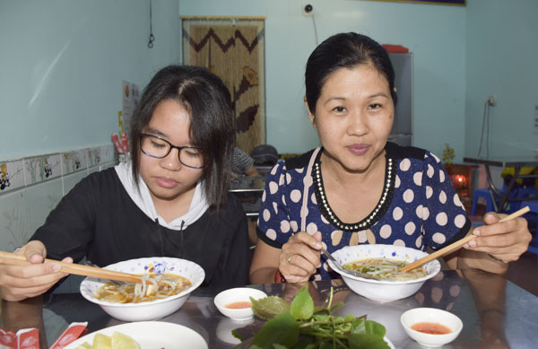 Chị Nguyễn Thị Mai Thảo và con gái thưởng thức bánh canh ghẹ Hoàng Long. 