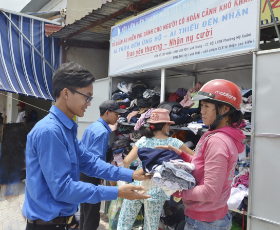 Chị Hoàng Thị Trang, vui mừng khi nhận túi đồ còn mới từ tay anh Huỳnh Thanh Thái.