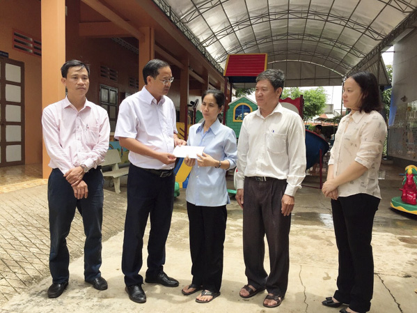 Ông Nguyễn Tấn Bản, Phó Chủ tịch UBND huyện Châu Đức trao 5 triệu đồng hỗ trợ Trường khuyết tật Mai Linh (xã Bình Giã).