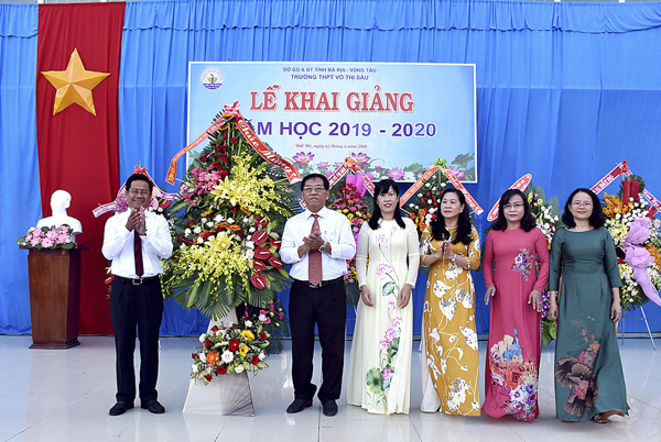 Ông Bùi Chí Thành, Ủy viên Dự khuyết Trung ương Đảng, Chủ tịch UBMTTQ Việt Nam tỉnh (bìa trái) tặng hoa chúc mừng Lễ khai giảng của trường THPT Võ Thị Sáu (huyện Đất Đỏ).