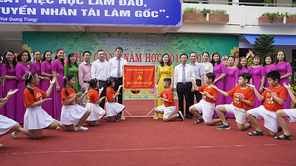 Đồng chí Trần Đình Khoa, Phó Chủ tịch HĐND tỉnh, Bí thư Thành ủy TP.Vũng Tàu (thứ chín, bên trái sang) trao Cờ thi đua xuất sắc năm học 2018-2019 của UBND tỉnh cho Trường TH Quang Trung (TP.Vũng Tàu).