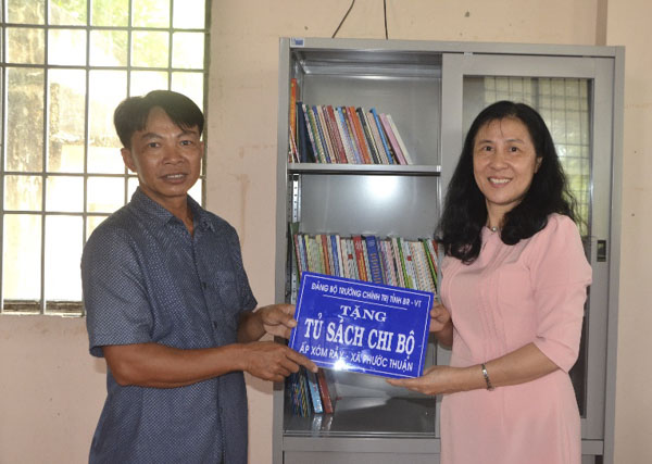 Bà Ngô Thị Liên, Hiệu trưởng Trường Chính trị tỉnh trao Tủ sách cho Chi bộ ấp Xóm Rẫy.