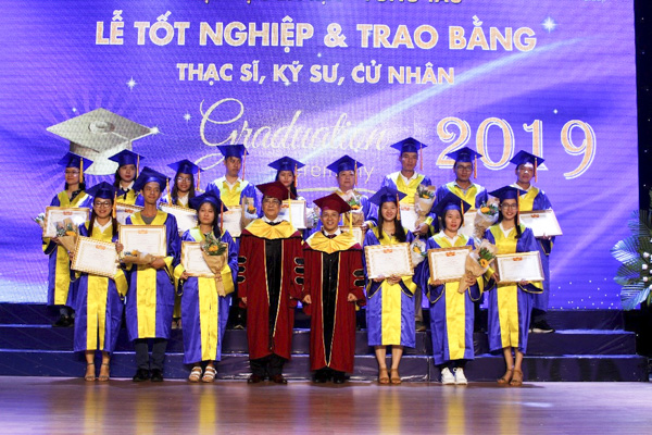 Ông Nguyễn Lộc (bên trái), Hiệu trưởng và ông Phạm Vũ Phi Hổ (bên phải), Phó Hiệu trưởng Trường ĐH Bà Rịa - Vũng Tàu trao giấy khen cho những SV tốt nghiệp đạt loại giỏi và xuất sắc.