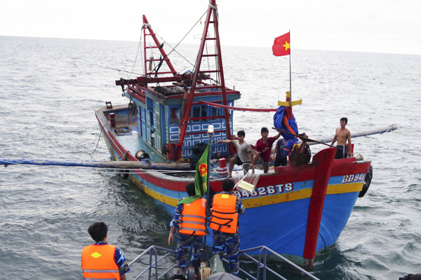 Lực lượng BĐBP đưa tờ rơi tuyên truyền pháp luật và bảo đảm ANAT dầu khí cho một tàu cá đang đánh bắt trên biển.