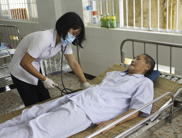 Chị Phạm Thị Hải Quý, nhân viên y tế phục hồi chức năng kiểm tra huyết áp cho đối tượng ở TTXH tỉnh. 