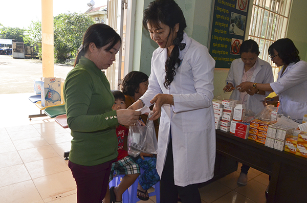 Bác sĩ hướng dẫn sử dụng thuốc cho người dân xã Bàu Lâm.