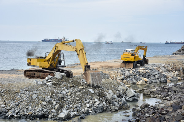 Các xe cuốc móc đất, đá san gạt mặt bằng lấn biển xây dựng công trình thủy cung.