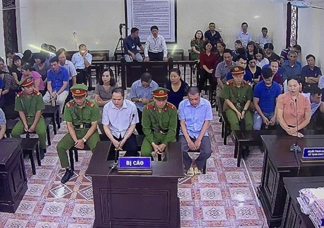 Các bị cáo (hàng giữa) tại phiên xử.
