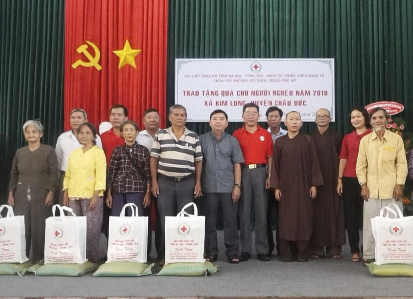 Ông Lê Văn Hậu, Chủ tịch Hội Chữ thập đỏ tỉnh (thứ 6 từ phải qua) cùng đại diện các chùa và nhà hảo tâm tặng quà cho các gia đình có hoàn cảnh khó khăn, hộ nghèo tại huyện Châu Đức.