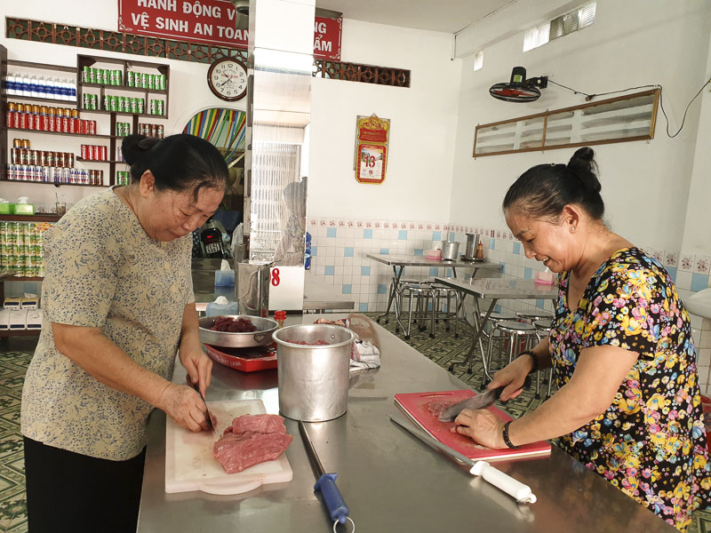 Bà Bùi Thị Nhung và Bùi Thị Kim Cúc (bên phải) thái thịt bò chuẩn bị món phở phục vụ khách.