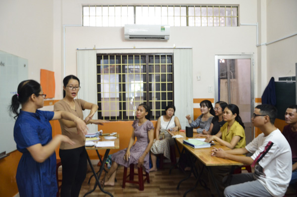 Từ trái qua, chị Nguyễn Thị Vân Anh và Hoàng Duy Phúc hướng dẫn các thành viên CLB Người điếc TP. Vũng Tàu cách sử dụng ngôn ngữ ký hiệu.