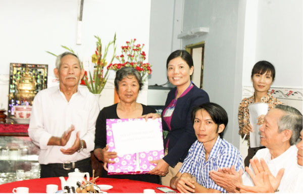 Chị Phương Hoa tặng quà cho bà Ngô Thị Kim Thanh  (KP 11, phường Thắng Nhất) tại buổi trao nhà Đại đoàn kết.
