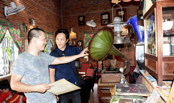 Anh Nguyễn Tân Hưng (phải) và Nguyễn Lê Phi Long trao đổi kinh nghiệm chọn đồ xưa. 