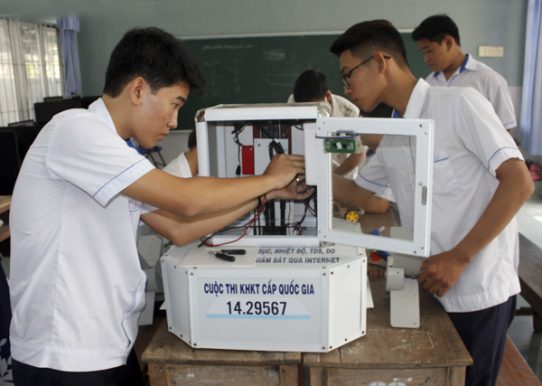 Em Đỗ Thành Đạt (bên trái) và Nguyễn Trung Hiếu kiểm tra lại “Thiết bị đo pH, độ đục, nhiệt độ, TDS, DO cho nuôi thủy sản giám sát qua Internet”.