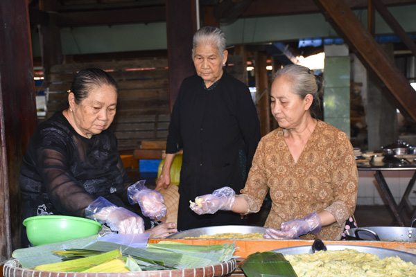 Người dân Long Sơn chuẩn bị làm bánh ít đãi du khách thập phương  tham quan Nhà Lớn.