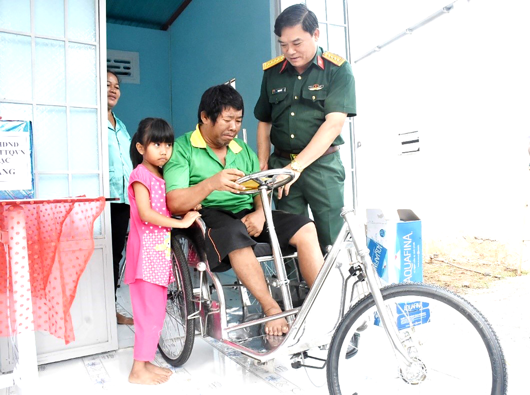 Đại tá Phạm Phú Ý, Ủy viên Ban Thường vụ Tỉnh ủy, Chỉ huy trưởng Bộ CHQS tỉnh trao xe lăn cho ông Dương Văn Lộc.