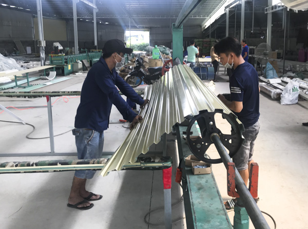 Công nhân Công ty TNHH SX-TM-DV Nam Cường Đoàn Kết đang  sản xuất cửa cuốn.