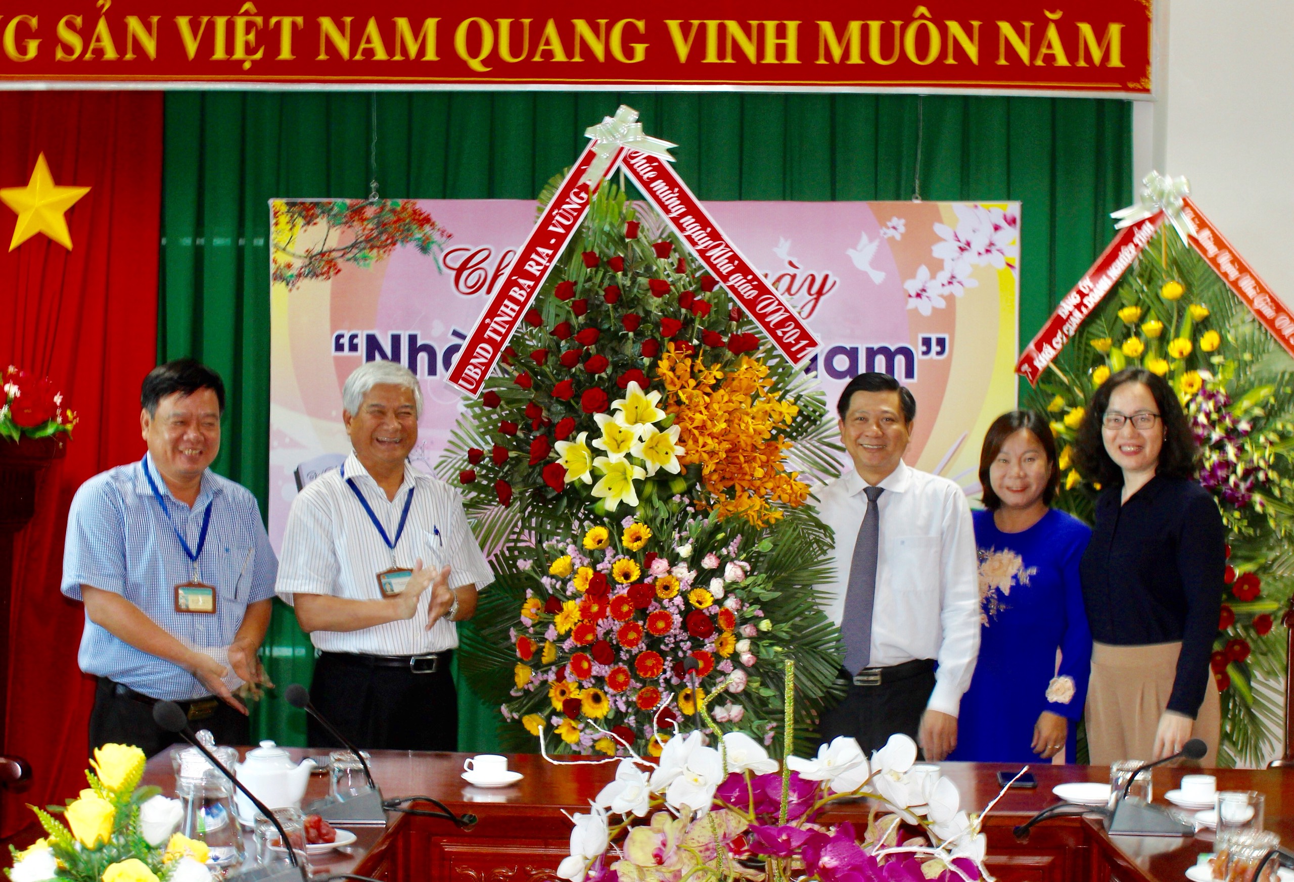 Ông Trần Văn Tuấn, Phó Chủ tịch UBND tỉnh (thứ 3 từ phải qua) tặng hoa chúc mừng Sở GD-ĐT.