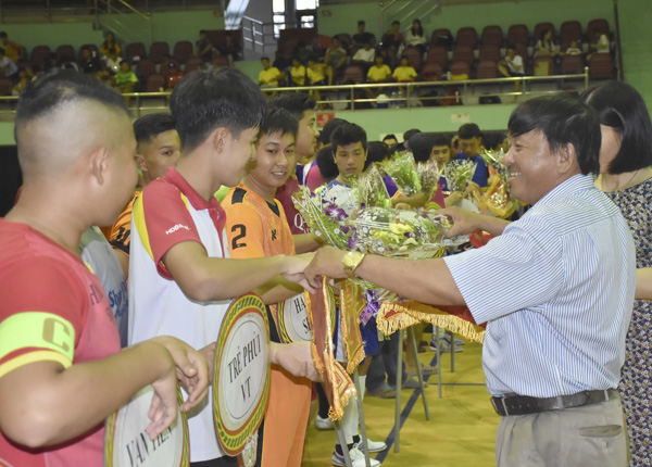 Ông Đặng Văn Cường, Giám đốc Trung tâm HL&TĐTDTT tỉnh, Phó Ban Tổ chức giải trao cờ lưu niệm và hoa cho các đội về dự giải.