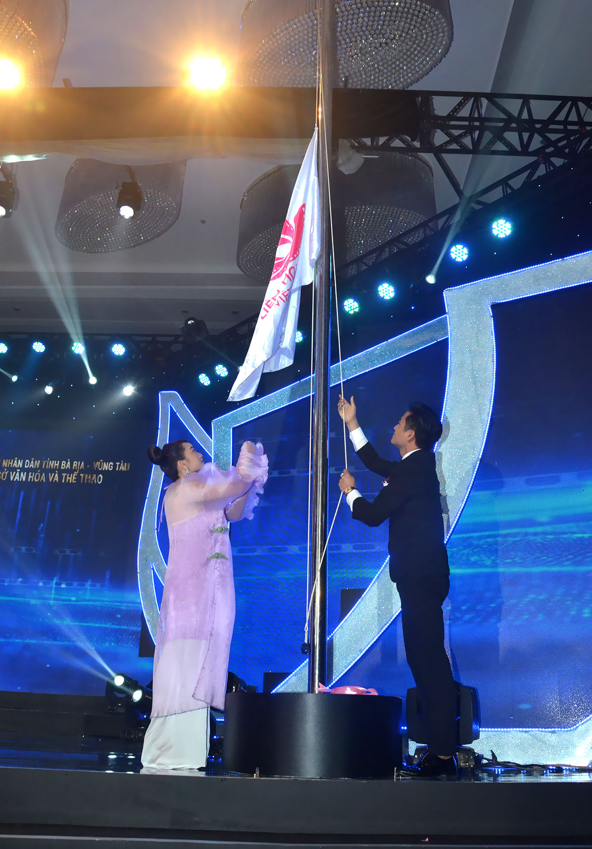 Diễn viên Quý Bình và Kaity Nguyễn thực hiện nghi thức kéo cờ khai mạc Liên hoan Phim Việt Nam lần thứ 21.