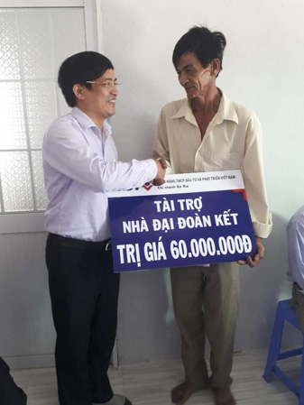 Ông Trần Văn Nhân, Phó Giám đốc Ngân hàng BIDV, Chi nhánh Bà Rịa trao nhà đại đoàn kết cho gia đình ông Hoàng Thiên. 