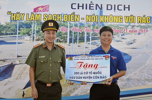Đại diện Cục Hậu cần, Bộ Công an trao tượng trưng 300 lá cờ Tổ quốc cho ngư dân huyện Côn Đảo.