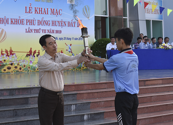 Ông Lê Văn Hòa, Chủ tịch UBND huyện nhận đuốc từ VĐV để thực hiện nghi thức châm đuốc khai mạc Hội khỏe Phù Đổng huyện Đất Đỏ năm 2019. 