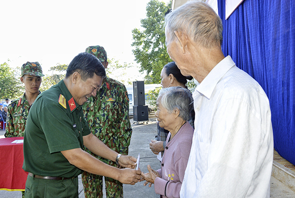 Đại tá Nguyễn Hoàng Tấn, Phó Chính ủy Bộ CHQS tỉnh tặng quà cho các hộ dân có hoàn cảnh khó khăn trên địa bàn xã Phước Tân.