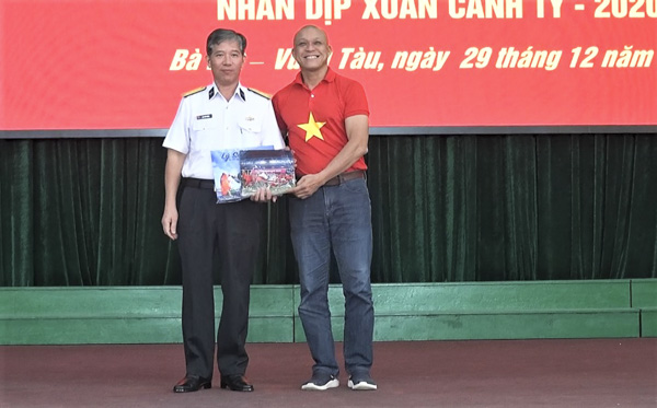 Đại tá Đinh Văn Thắng (bên trái), Phó Tư lệnh Vùng 2 Hải quân nhận một số tác phẩm ảnh về biển, đảo do Nghệ sĩ nhiếp ảnh Nguyễn Á trao tặng.