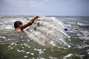 Một em nhỏ sử dụng ván lướt sóng được làm từ các chai nhựa tham gia chiến dịch nâng cao ý thức cho cộng đồng về tác hại của chất thải nhựa đối với đại dương, tại Lima, Peru. 