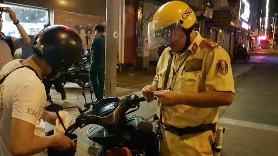 CSGT tiến hành kiểm tra nồng độ cồn với người điều khiển xe mô tô tối 2/1/2020. Ảnh: SGGP