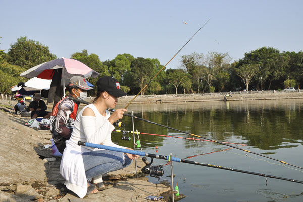 Người dân và du khách câu cá tại Khu vực câu cá giải trí trong khuôn viên di tích Bàu Thành..