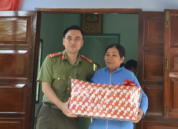 Thượng úy Trần Hoàng Linh, Bí thư Đoàn cơ sở Công an huyện Đất Đỏ tặng quà bà Trần Thị Đây, con liệt sĩ tại lễ bàn giao nhà.