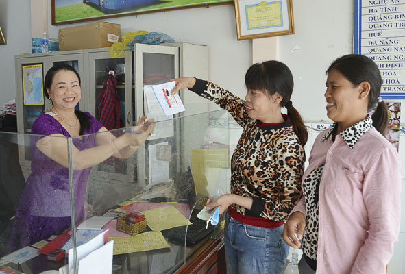 Chị Phan Thị Hiếu và chị Phan Thị Hoàn (bìa phải) mua vé xe về Quảng Bình tại nhà xe Minh Phúc chiều 14/1. 