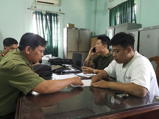 Trần Văn Tùng (bên phải) khai báo với cơ quan an ninh về hành vi tung tin thất thiệt trên facebook với nội dung tại Bệnh viện Lê Lợi có 2 trường hợp nghi nhiễm virus Corona.